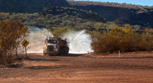 Water truck performing road maintenance at a mine site